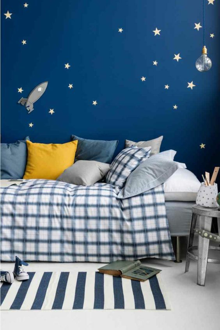 décoration chambre garçon avec mur bleu avec multitude d étoiles et lit a la couverture carrée