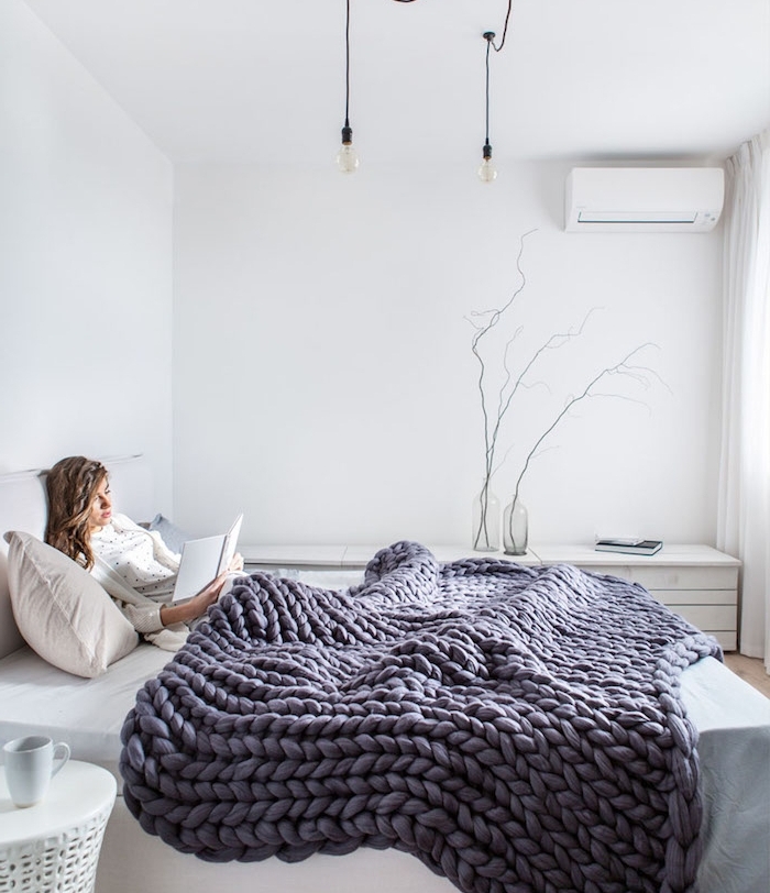 idée déco chambre cocooning, avec linge de lit blanc, couverture en laine à grosse mailles pour une ambiance chaleureuse, table de nuit blanche
