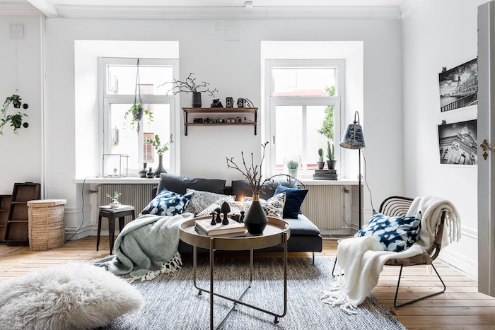 idee deco cocooning avec canapé gris, chaise et table design scandinave couverture enveloppante, pouf avec taie de fausse fourrure, murs blancs, coussins gris, blanc bleu