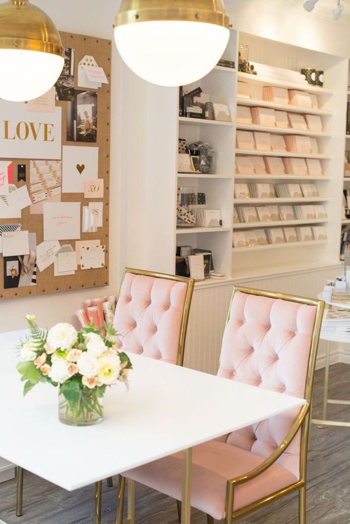 salle à manger aux murs blancs, table à manger blanche avec chaises rose pastel, tableau décoratifs avec notes et photos