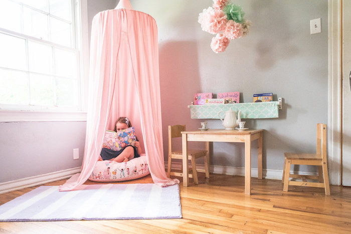coin de lecture dans la chambre fille, décoration pompons en serviettes rose et vert, tapis rayé en blanc et violet