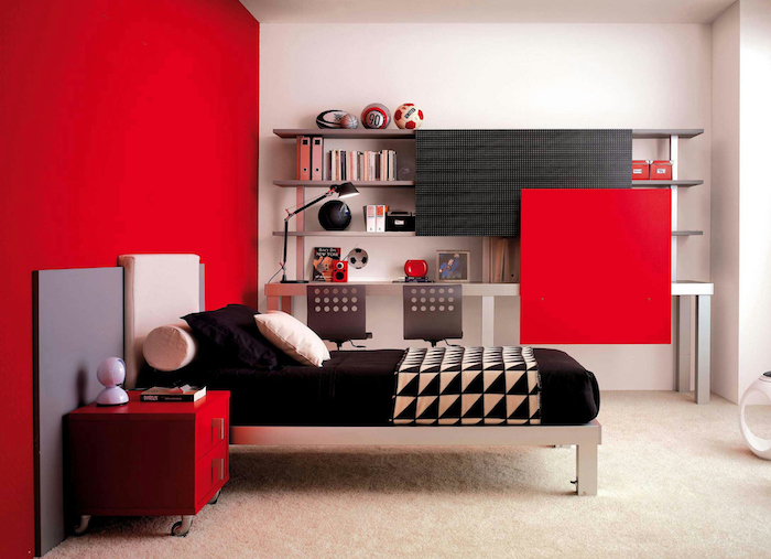 deco rouge et noir, mur d accent rouge et table de nuit avec tiroirs rouges, lit en inox, matelas et coussins noirs, étagère bibliothèque simple, tapis blanc