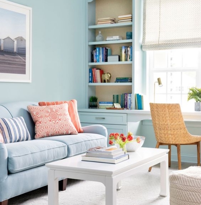 salon blanc et beige introduits par petites touches, tapis et table basse blancs, chaise beige, canapé et mur couleur bleue