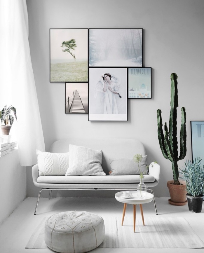 deco salon gris et blanc, canapé blanc, pouf et tapis gris, table basse minimaliste scandinave, deco murale de cadres, peinture et photos, cactus et autres plantes