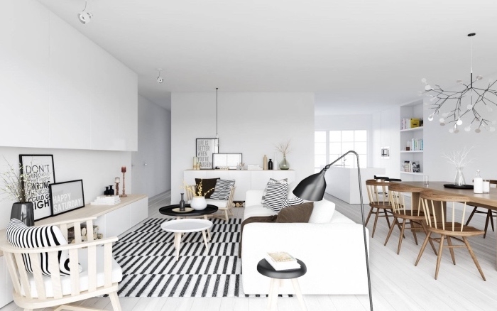 amenagement salon scandinave ouvert sur salle à manger, tapis noir et blanc, canapé blanc, chaises en bois, parquet clair, salle à manger chaises et table en bois