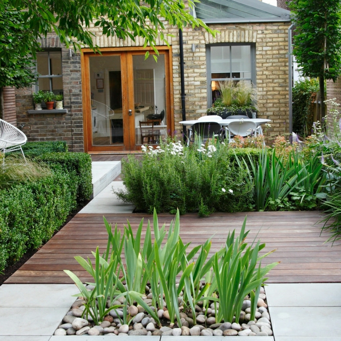 deco terrasse exterieure, dalles de béton, galets, buis et arbustes verts, zone revêtement en bois, une maison moderne