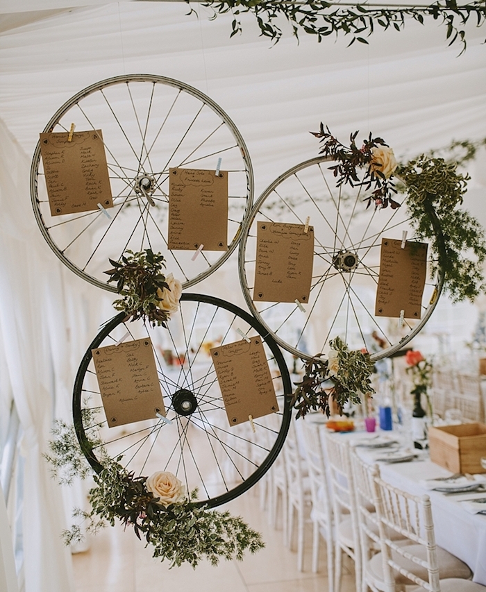 decoration mariage champetre chic, plan de table original en roues de vélo avec deco florale, branches vertes, roses