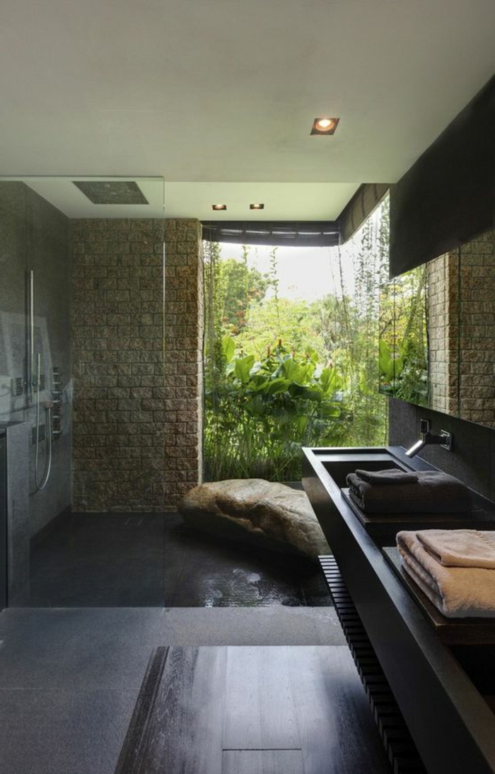 décoration salle de bain, murs en pierren sol en béton noirn douche plain pied