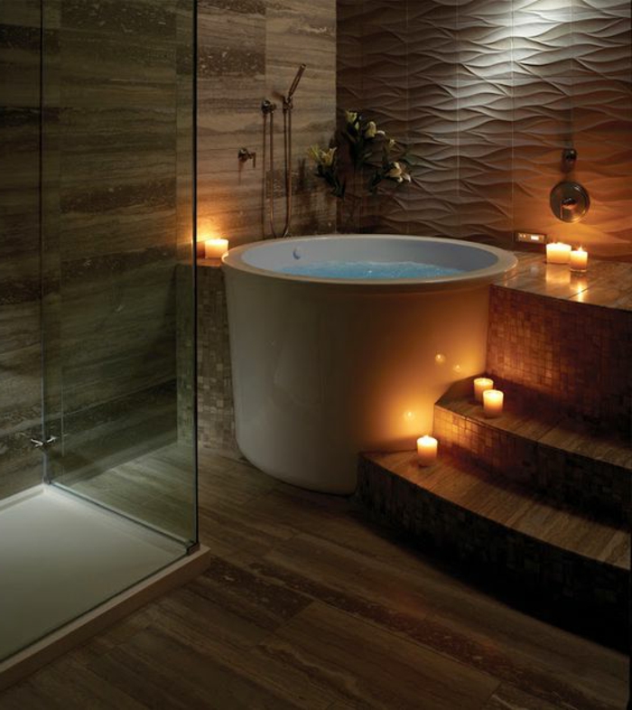 decoration salle de bain, baignoire ronde blanche, bougies alumées, parement bois et plâtre