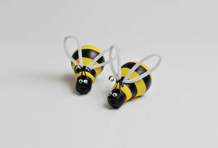 des abeilles fabriquées à partir d ampoules électriques, décorées de bandes noires et jaunes, des yeux mobiles et ails, déco avec de la récup