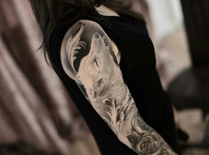 signification tatouage, tatouage bras entier pour femme, dessin à motifs floraux avec tête de loup