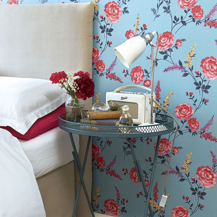 idée de déco bleu et rouge, papier peint bleu à motif floraux roses rouges, table de service bleue, lit gris clair et linge de lit blanc et rouge
