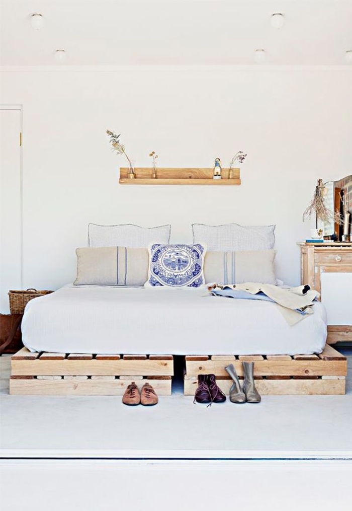 chambre à coucher en blanc et bois de style scandinave et d'esprit minimaliste avec un lit en palette fonctionnel et gain-d'espace 