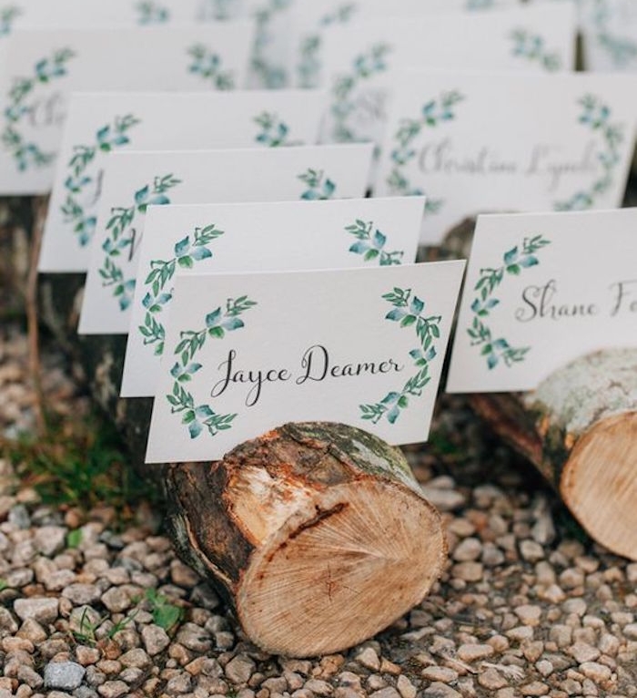 plan de table mariage en bûches de bois, façon rustique avec des étiquettes prénom, nom invité et dessin laurier