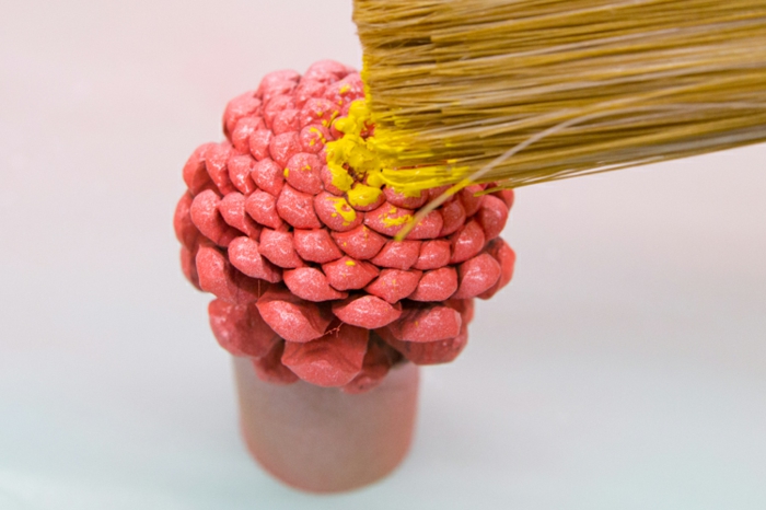 décoration de noel à fabriquer, peindre une pomme de pin rose et jaune