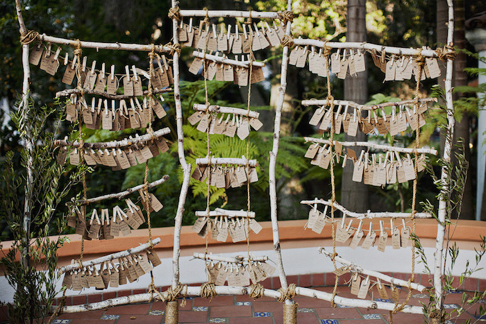 modele de plan de table mariage en bois flotté, branches de bois transformée en petite échelle avec étiquettes en papier kraft pour écrire le nom des invités