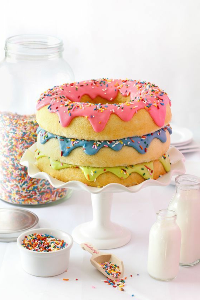 gateau d'anniversaire en forme de trois Donuts géants avec une multitude de perles colorées et des glacages en couleurs attrayantes