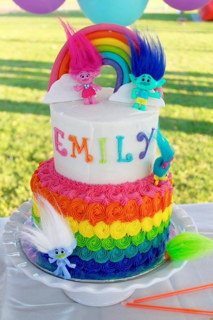 recette gateau d'anniversaire sur le thème des trolls avec un arc en ciel au sommet et des pointes colorées a la base 