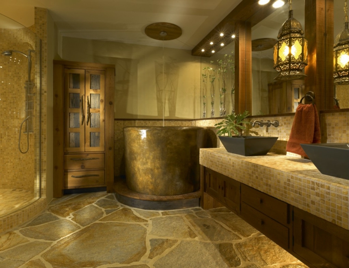 idee de salle de bain, sol en pierre naturelle, baignoire ronde, comptoir en mosaique, vasques noires