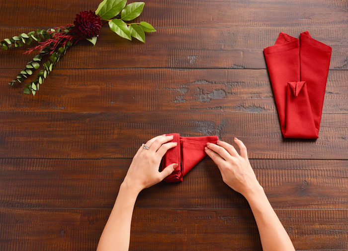pliage serviette, comment plier une nappe de table rouge en forme animal, table en bois marron foncé