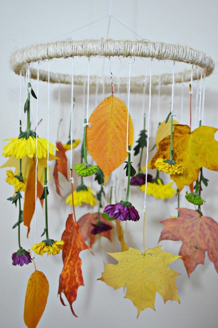 un mobile de feuilles mortes et fleurs colorées, cerceau, enveloppé de laine, avec des feuilles suspendues à des fils blancs, activité manuelle automne facile