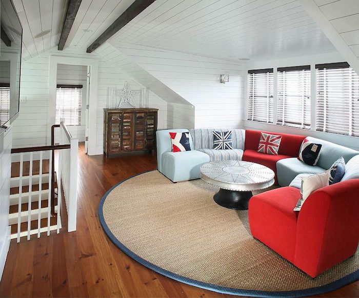 idée deco bleue et rouge, canapé bleu, rouge, table basse design, tapis rond beige, parquet en bois clair, mur et plafond en lambris blanc