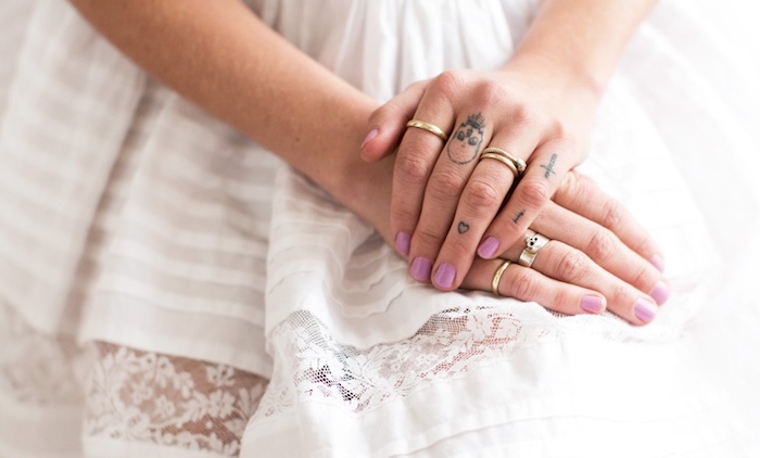 manucure rose ongles courts, petits tatouages sur les doigts féminins, bagues en or pour femme, robe blanche rayée