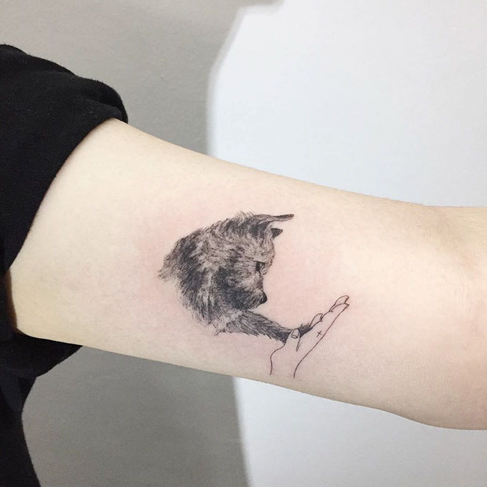 amitié entre homme et animaux, petit tatouage à design mignon sur le bras, idée dessin en encre