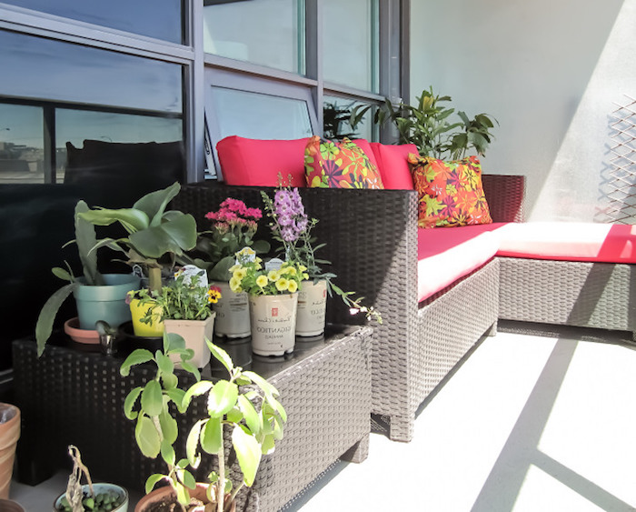 idee terrasse blanche avec canapé et table de service en rotin, salon tressé, coussins d assise dossier rose et coussins décoratifs colorés, plantes vertes