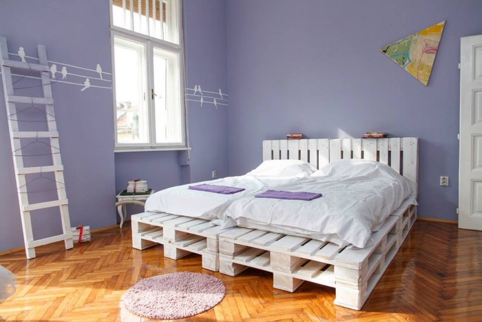 une chambre à coucher douce et féminine en violet avec un sommier en palette peinte en blanc et sa tête assortie