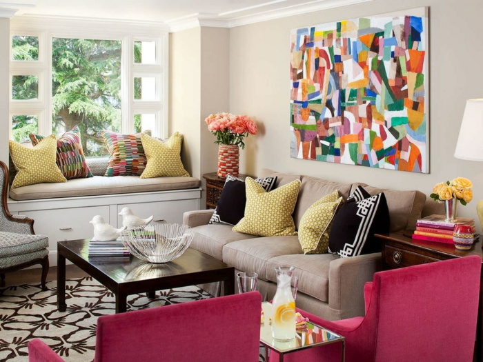 meuble gris, fauteuils roses, tapis à motifs originaux, coussins déco, tableau abstraitn table en bois foncé