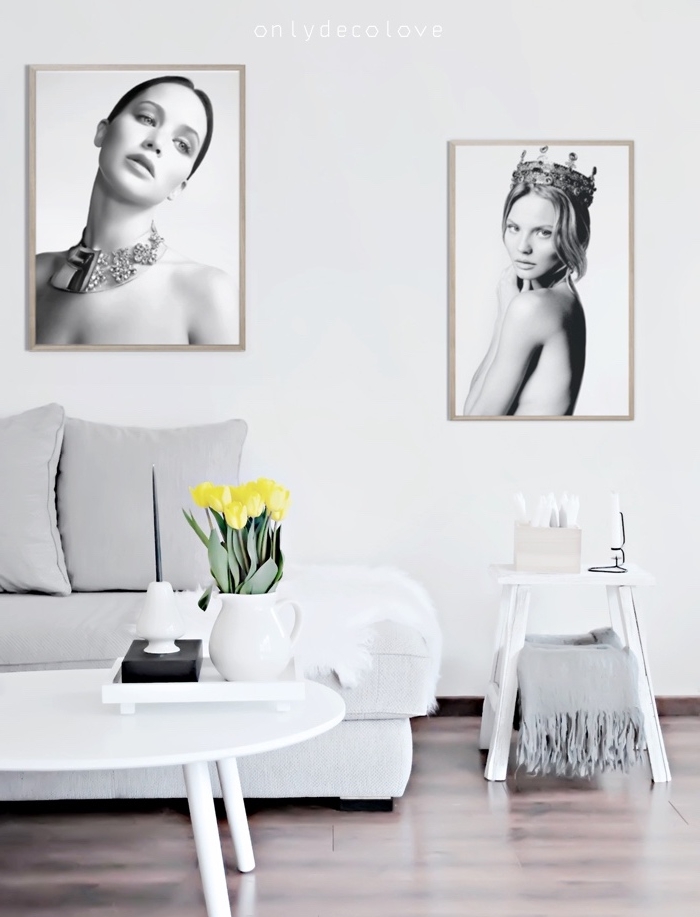 meubles scandinaves dans un salon gris et blanc, canapé blanc, coussins gris, parquet marron, table basse blanche, deco de photos en noir et blanc
