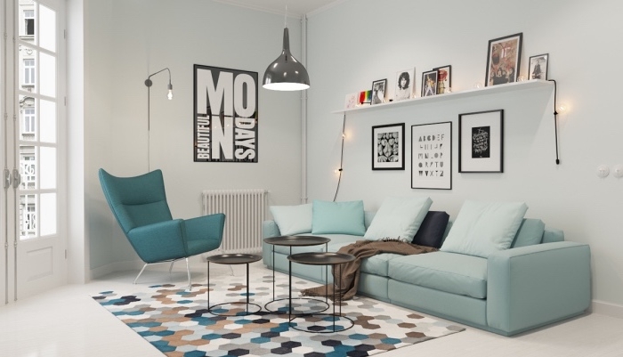 mobilier scandinave en canapé bleu pastel et chaise bleu canard, tapis à motifs géométriques, tables basses noires, étagère blanche, rangement photos, suspension grise design