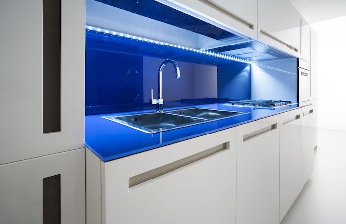 idee deco cuisine, meubles blancs de cuisine sans poignées, éclairage néon bleu sous meubles