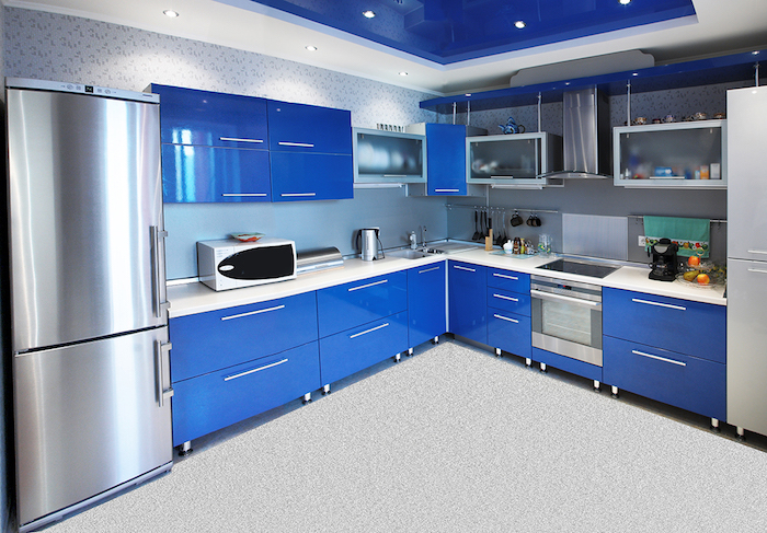 cuisine semi ouverte, plafond en blanc et bleu avec éclairage LED, meubles de cuisine bleus avec poignées gris