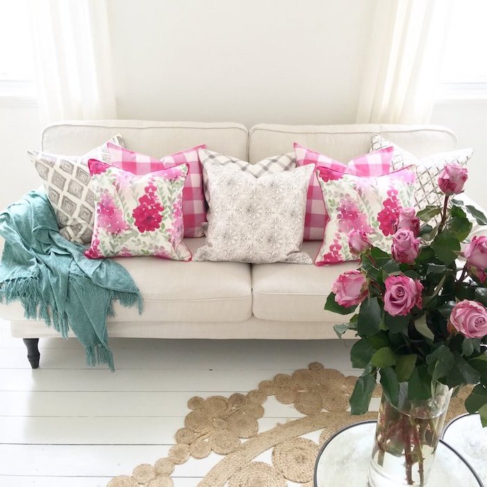 tendance deco, salon aux murs et plancher en blanc, bouquet de rose en vase verre, coussins à motifs floraux rose et blanc
