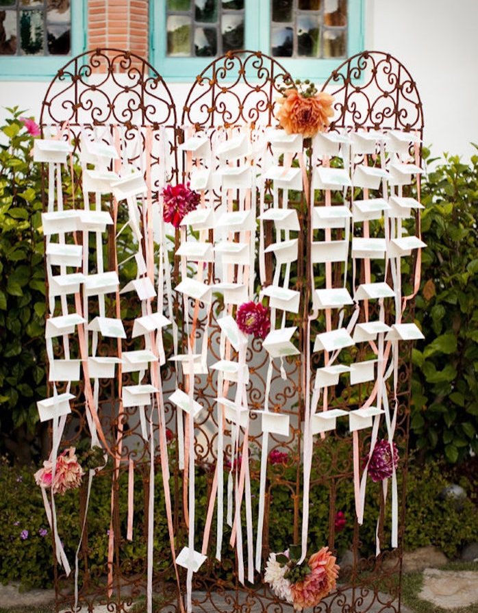 plan de table mariage diy avec des portes, grille métallique style baroque, décoration de rubans blancs et rose, fleurs épanouies et étiquettes blanches