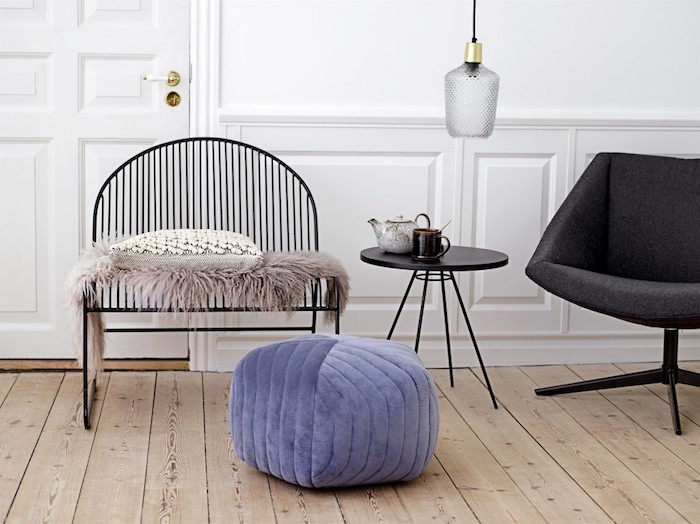 deco cocooning scandinave, parquet clair, chaise metallique noire avec pouf violet, jeté de fourrure, fauteuil gris anthracite et mur blanc