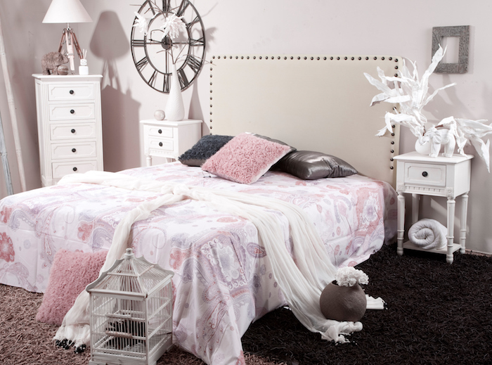 deco maison, voiles blanches sur le lit, couverture de lit à motifs dentelle et fleurs rose, lampe de chevet blanche