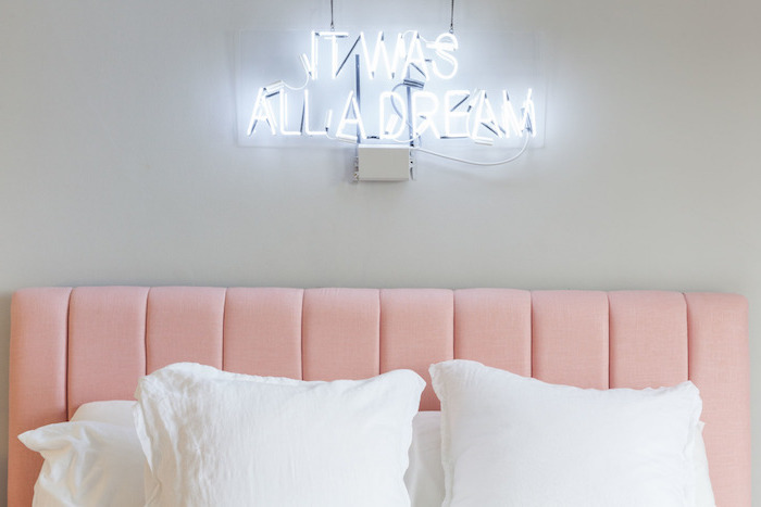 décoration chambre à coucher aux murs gris clair, tête de lit en rose, lettres lumineux au-dessus de lit