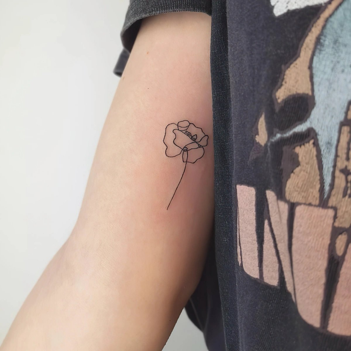 petit dessin lignes fines tattoo minimaliste fleur sur bras