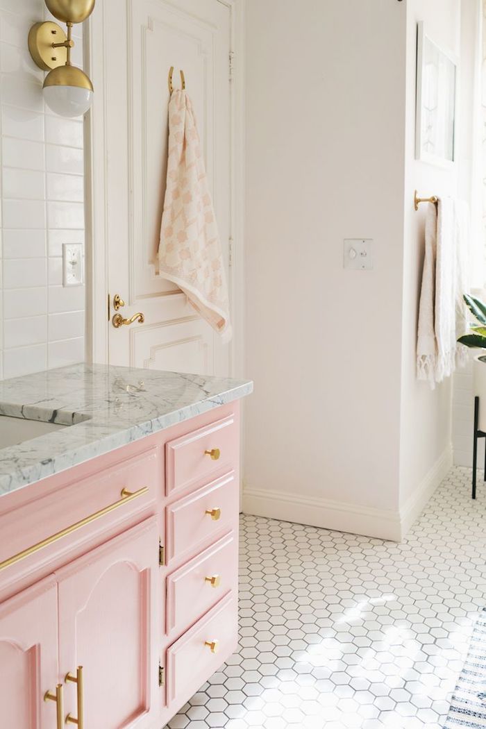 salle de bain renouvelé aux murs blancs, meubles en bois peints en rose pastel avec poignées dorées