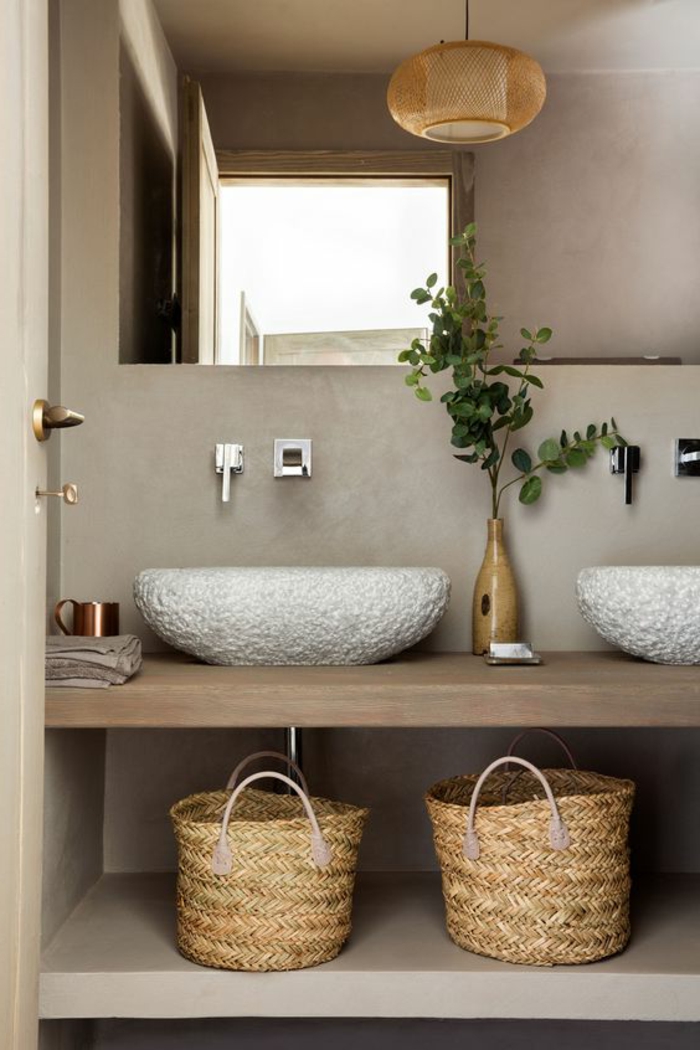 salle de bain cocooning, paniers tressés, vasques en pierre blanche, comptoir en bois, murs en béton