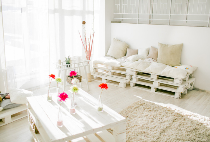 salon doux et ensoleillé en blanc immaculé avec un canapé et une table en palettes récupérées peintes en blanc, idee avec des palettes pour une déco récup