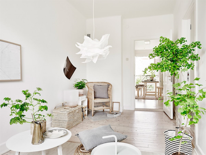 deco salon cocooning blanc et bois, parquet clair, paniers et chaise en rotin, suspension blanche, table basse blanche, plantes vertes
