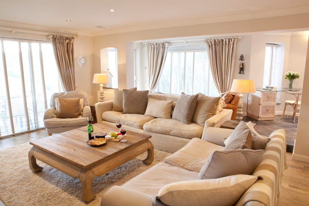 salon couleur lin, camaïeux de beiges, canapé, tapis, coussins beige avec accents gris et table basse en bois, plafond blanc