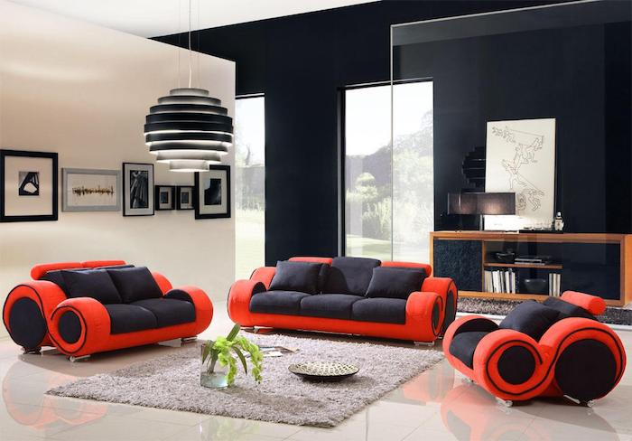 deco rouge et noir, canapés et fauteuil rouge et noir, tapis gris, carrelage blanc cassé, mur noir et blanc, suspension boule design