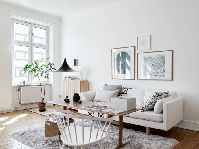 modele de salon scandinave blanc épuré, tapis gris, canapé blanc, coussins gris, blanc et noir, table en bois massif, chaise blanche, tapis scandinave, parquet clair