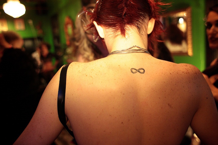 signe de l infini tatouage dans la nuque femme symbole éternité discret cou