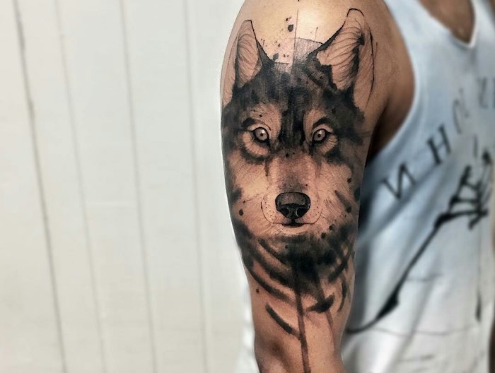 tatouage bras homme, dessin en encre à design tête de loup au regard feroce et aux lignes aquarelles